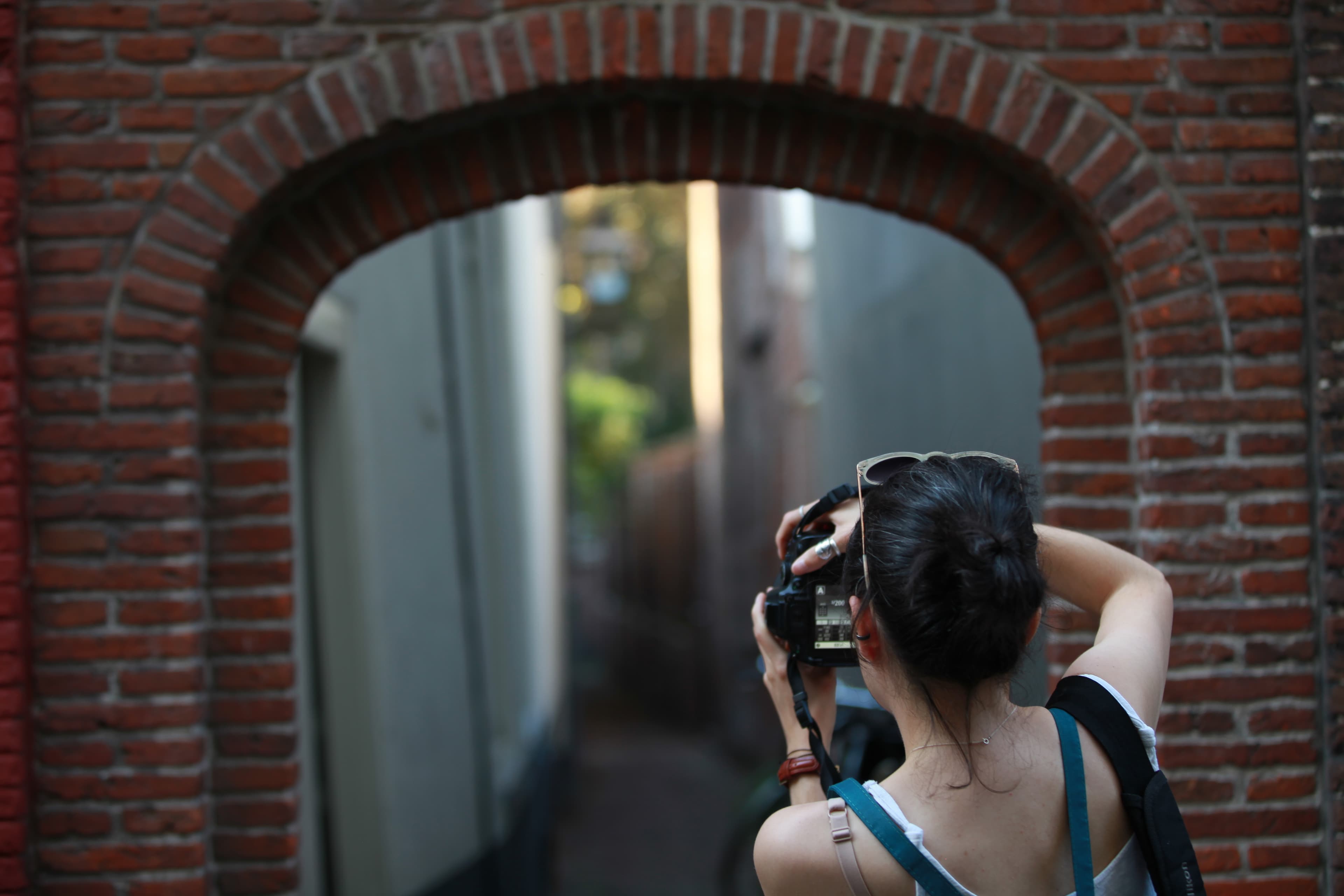 A photographer using a brick arch to frame a narrow Leiden view