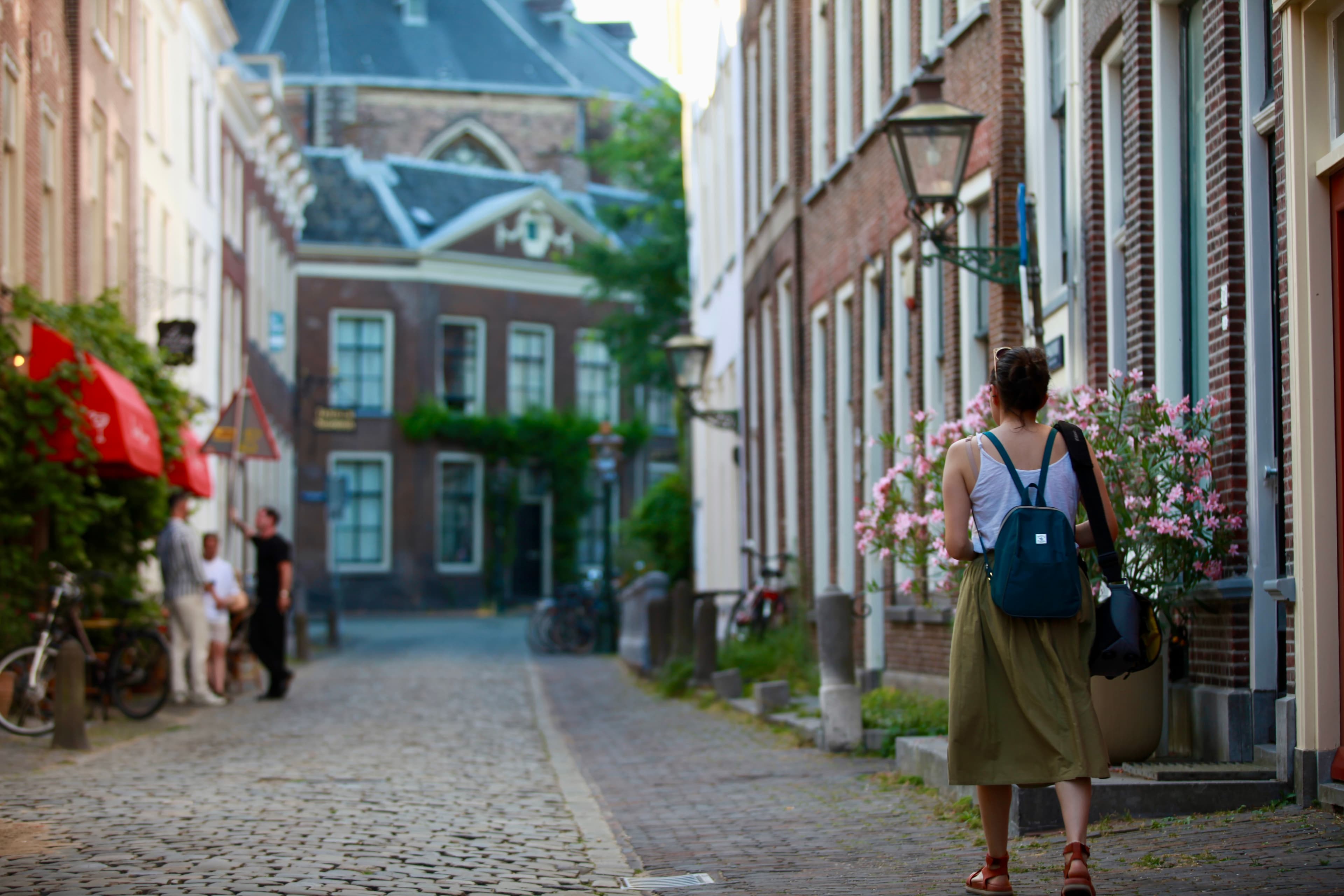 A woman walking along a quiet historic street in Leiden