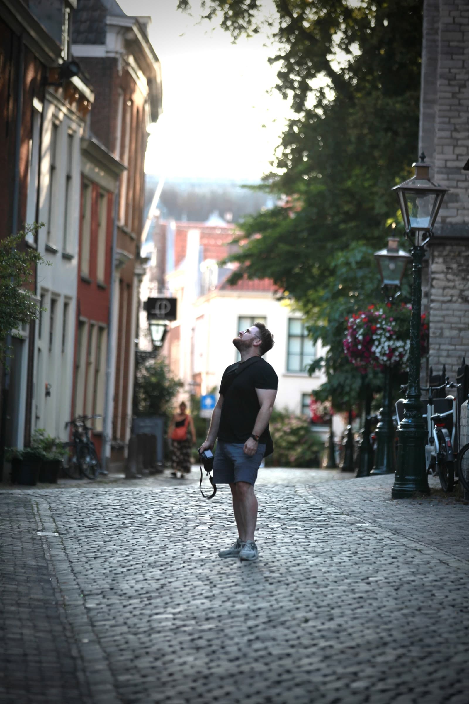 Visitor carrying a camera through an alley in Leiden