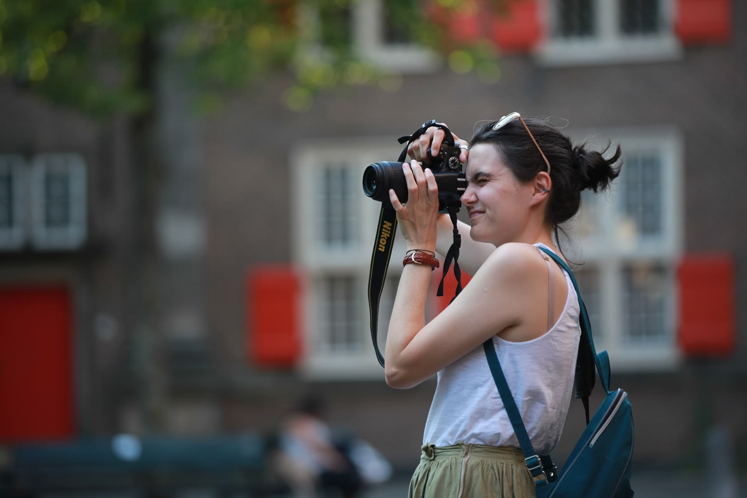 Photographer against a red-shuttered facade in Leiden