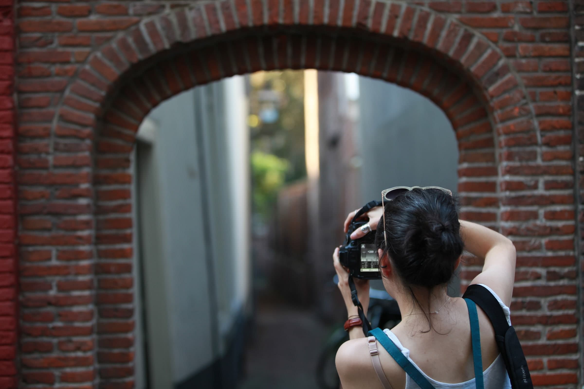 Photographer framed by a brick arch in Leiden