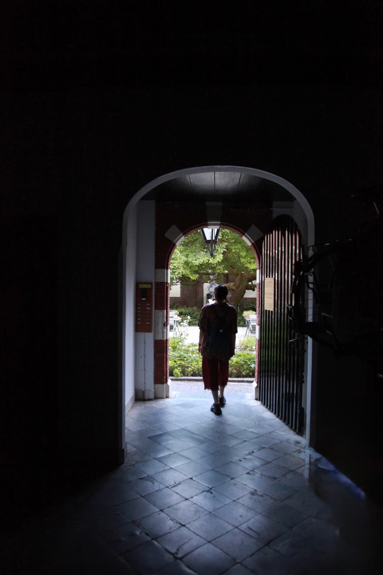 Visitor walking through an archway in Leiden