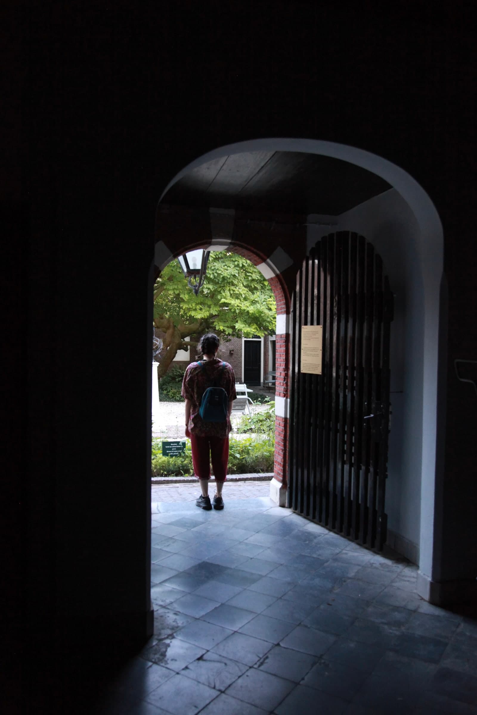Traveller framed in a courtyard gate in Leiden