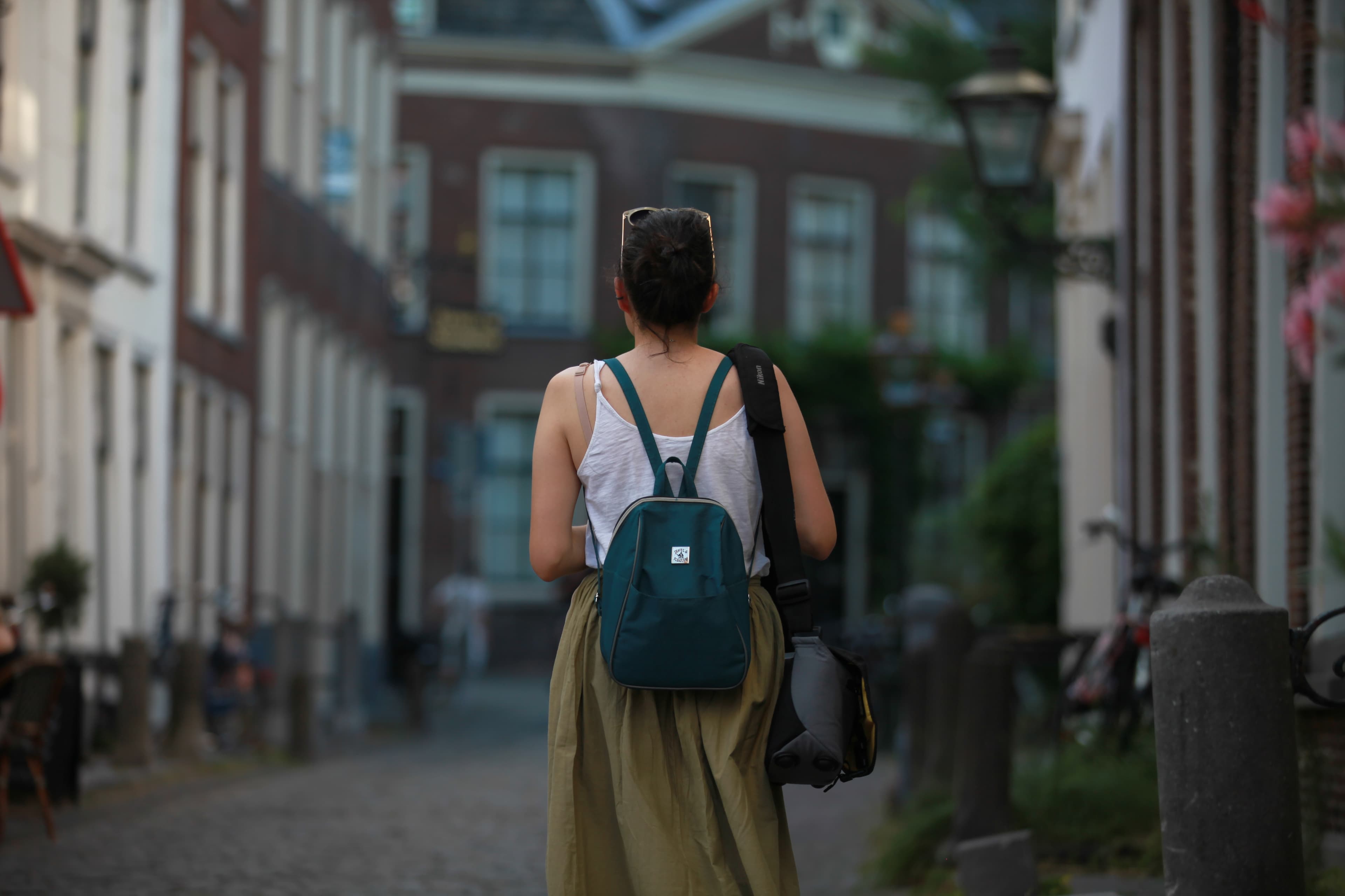 Photographer walking through a historic Leiden street with a camera