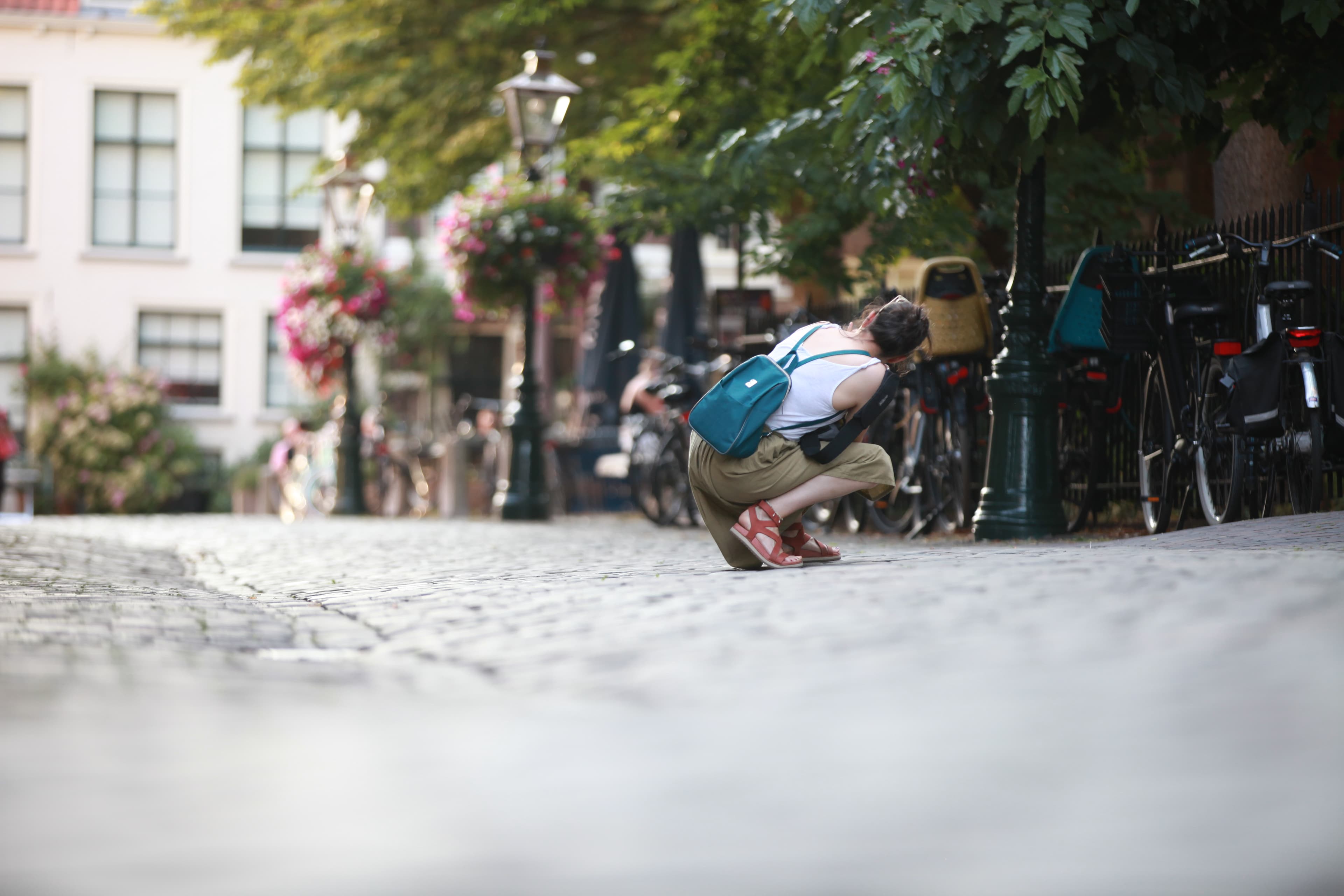 Photographer finding a low perspective on a cobblestone street in Leiden