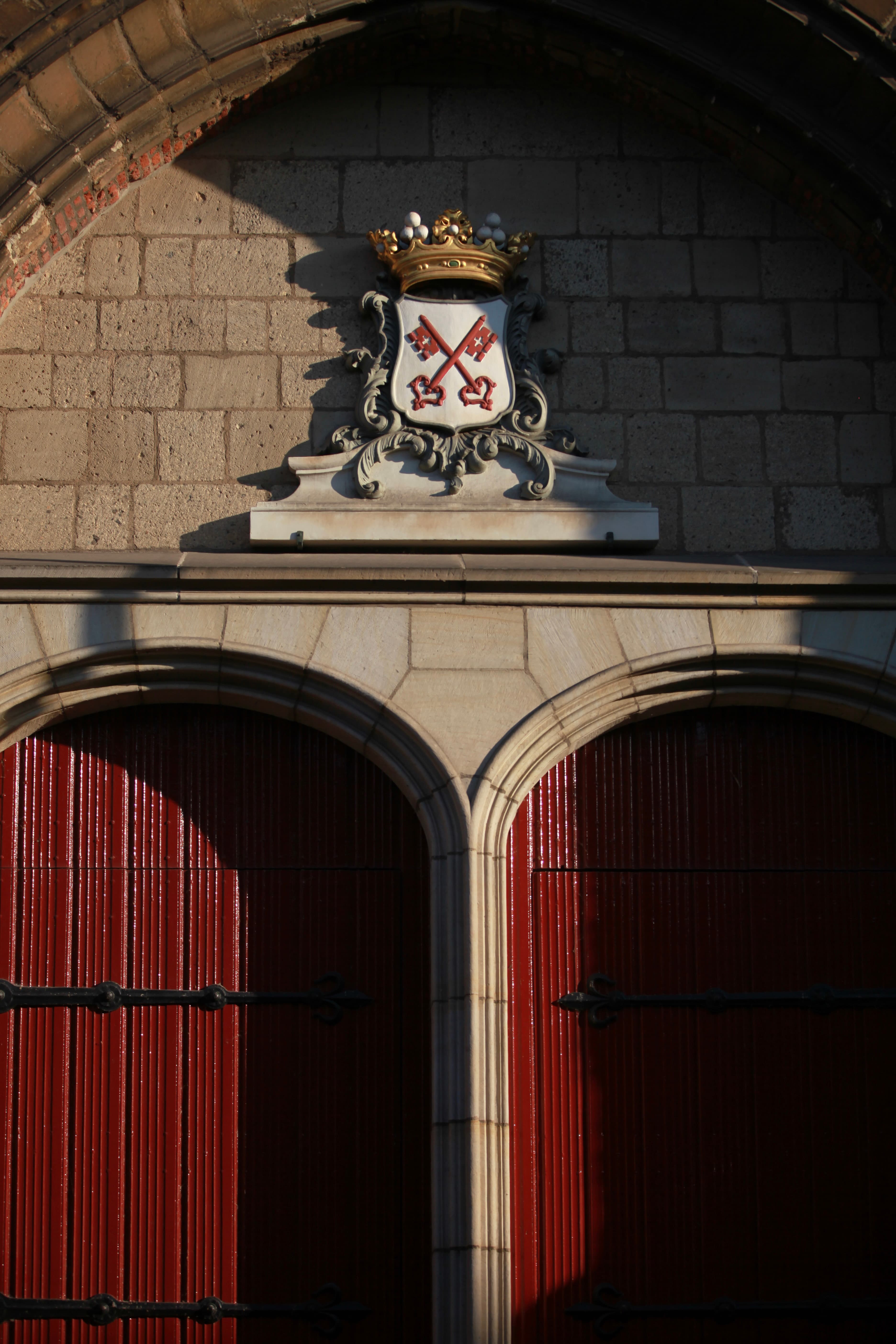 Historic red doors and Leiden crossed-keys crest in warm light