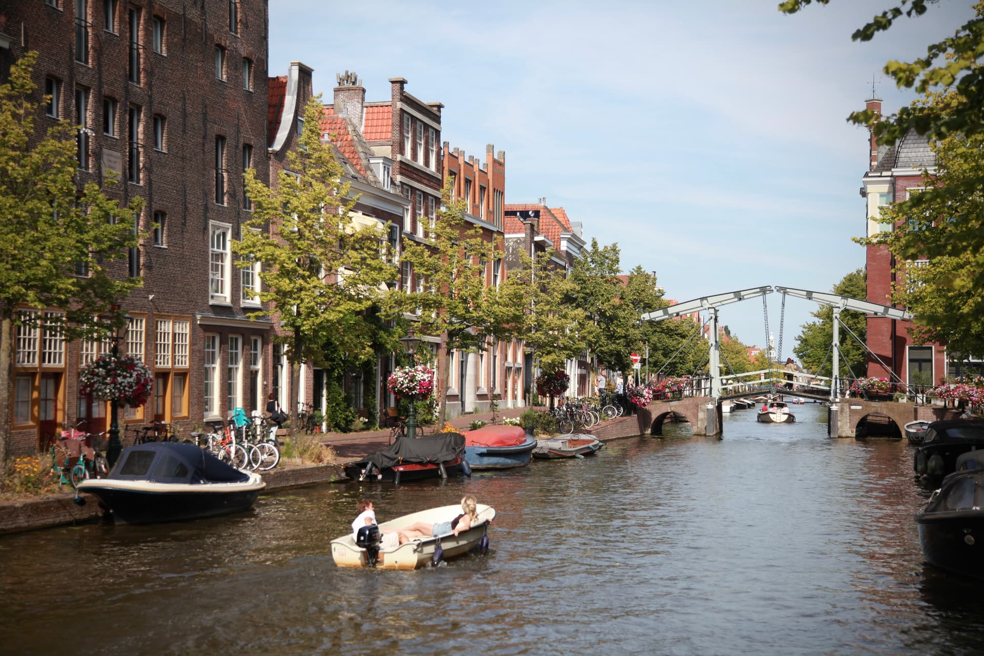 Boats and historic houses along a sunlit Leiden canal